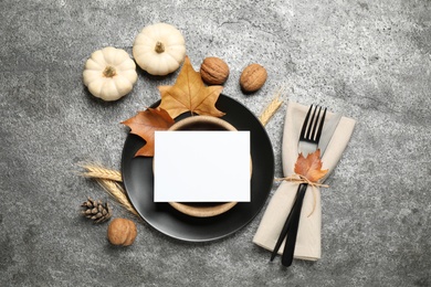 Photo of Festive table setting with pumpkins and autumn leaves on grey background, flat lay. Thanksgiving Day celebration