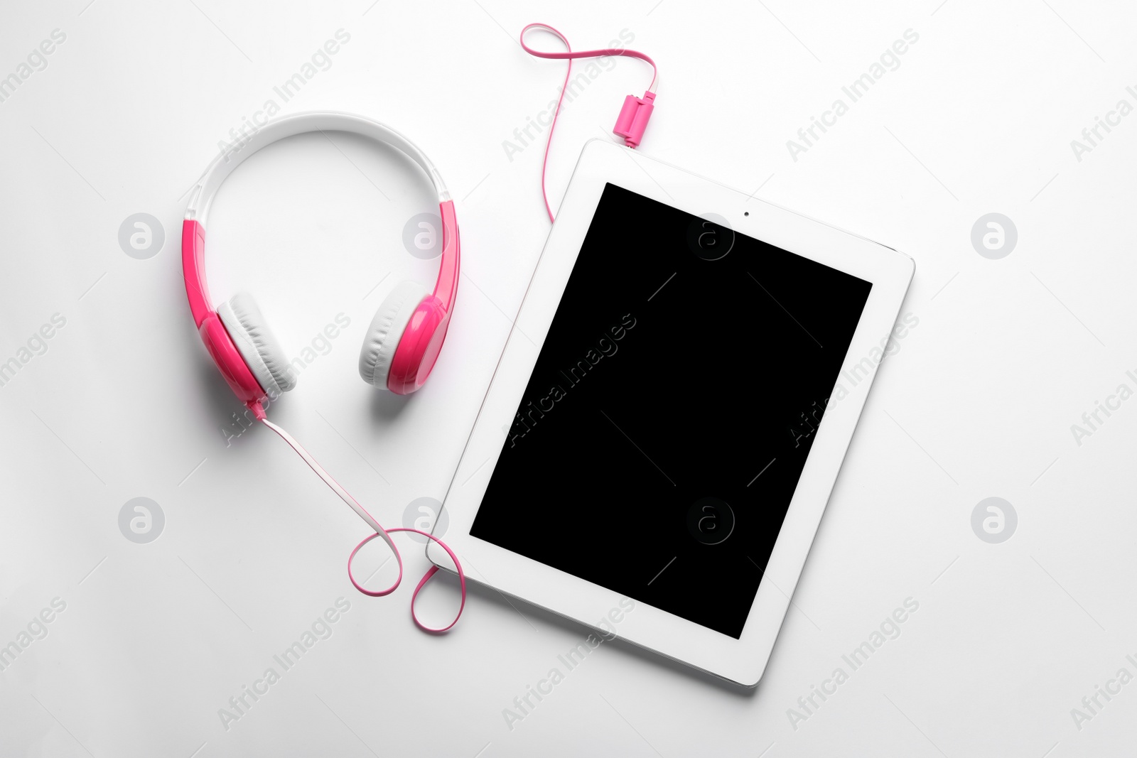 Photo of Stylish headphones and modern tablet on white background, top view. Space for text