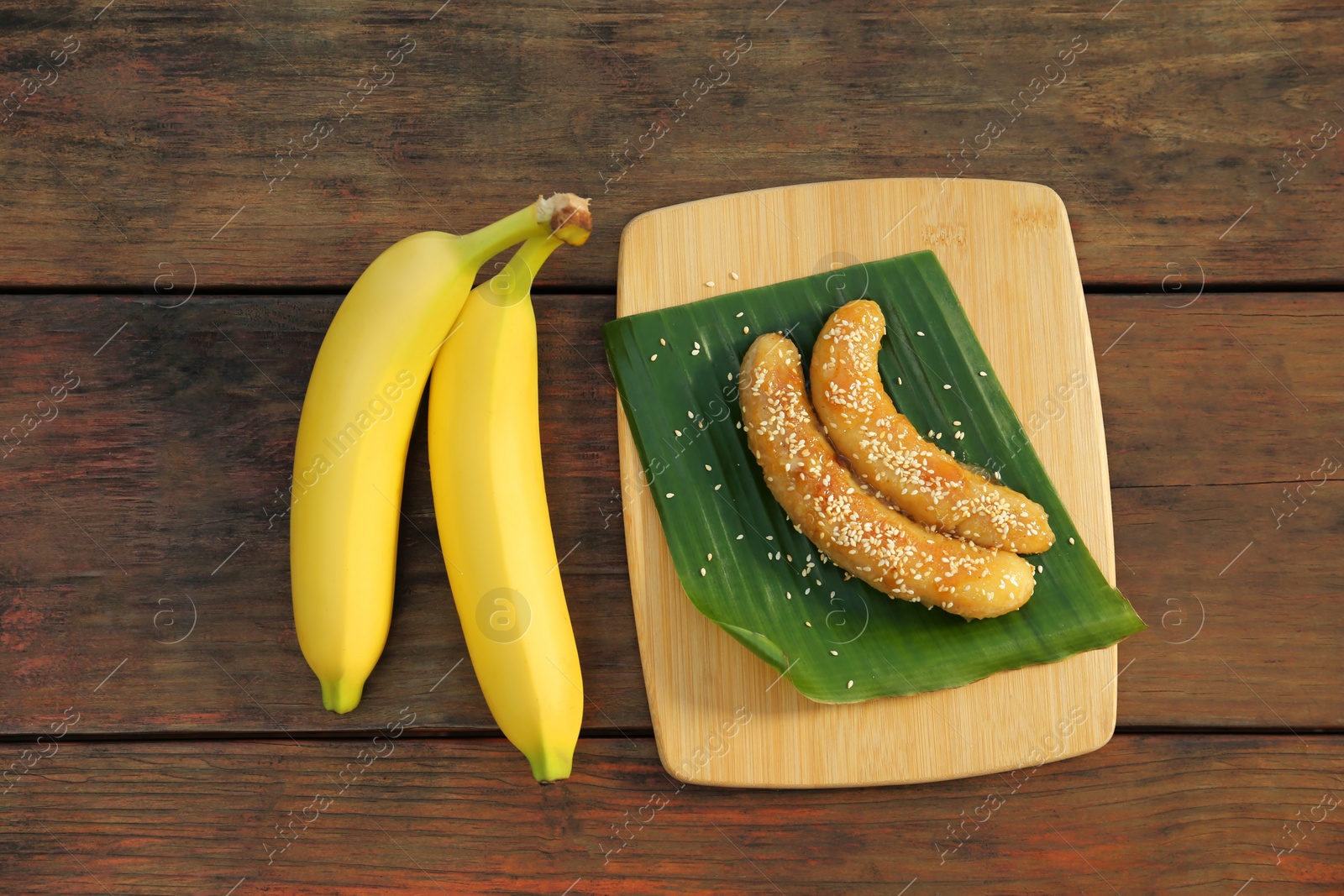 Photo of Delicious fresh and fried bananas on wooden table, flat lay