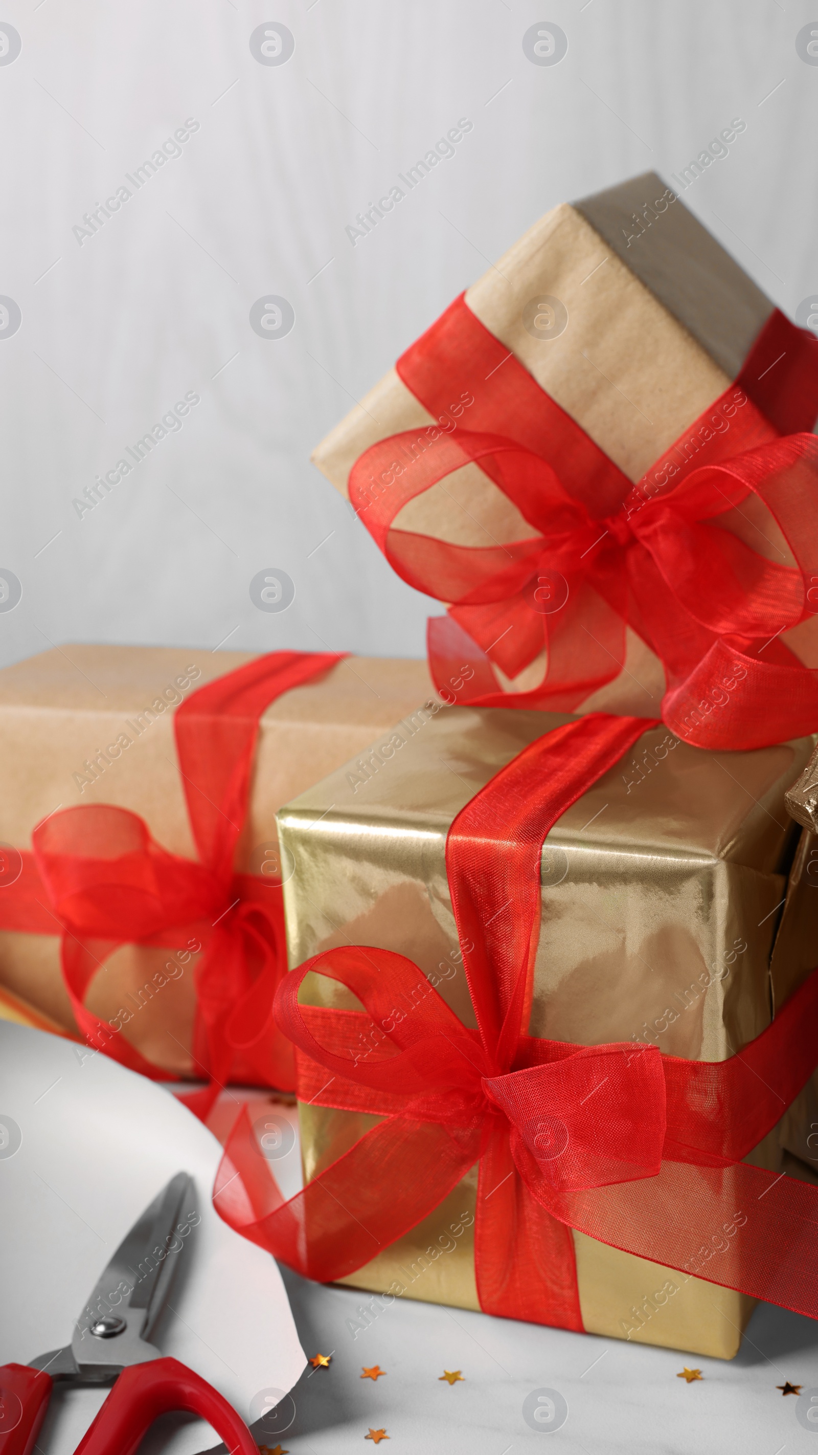 Photo of Beautifully wrapped gift boxes on white table, closeup