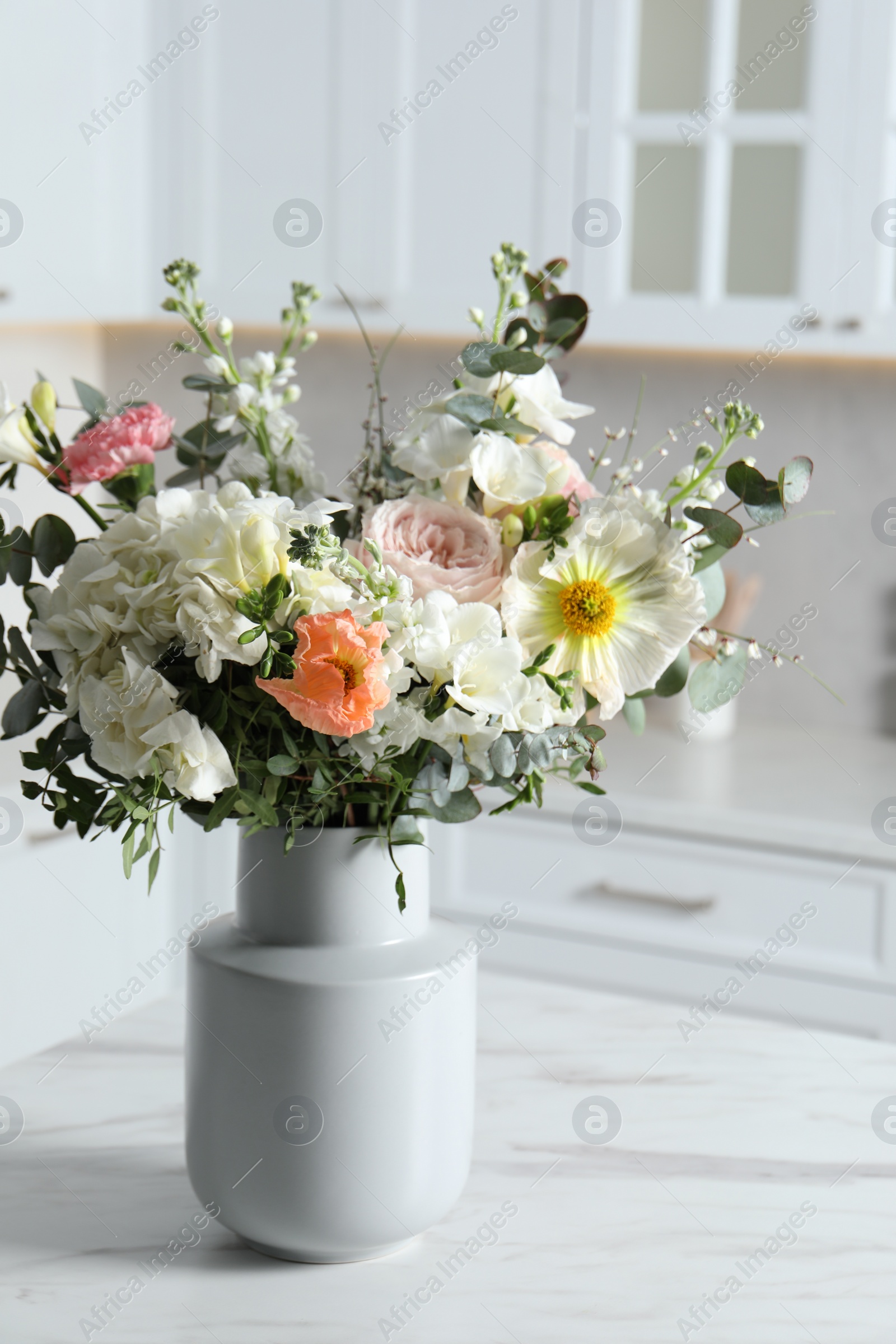 Photo of Bouquet of beautiful flowers on white table indoors