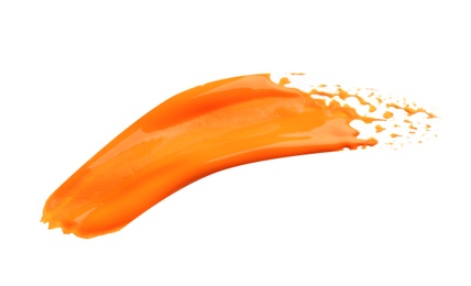 Photo of Abstract brushstroke of orange paint isolated on white