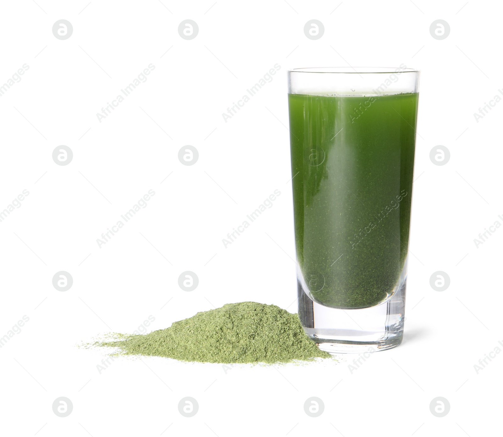 Photo of Wheat grass drink in shot glass and pile of green powder isolated on white