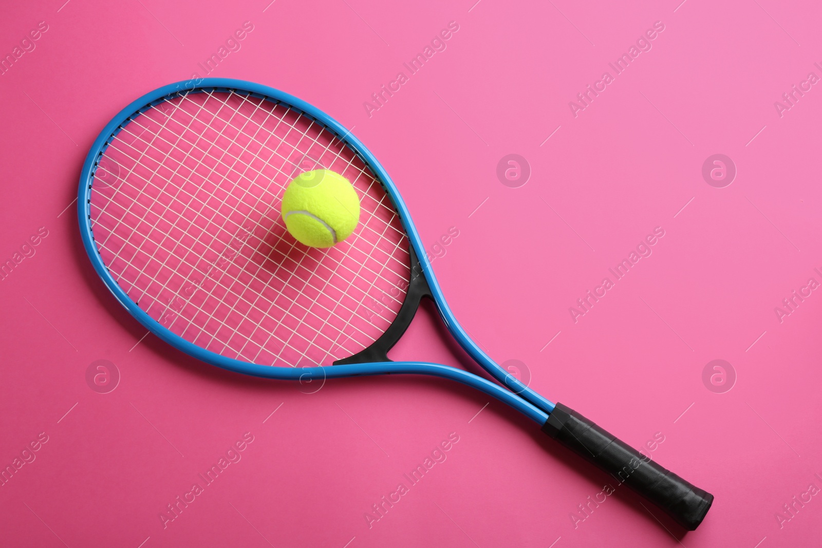 Photo of Tennis racket and ball on pink background, top view. Sports equipment