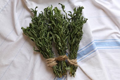 Bunches of wilted mint on white towel, flat lay
