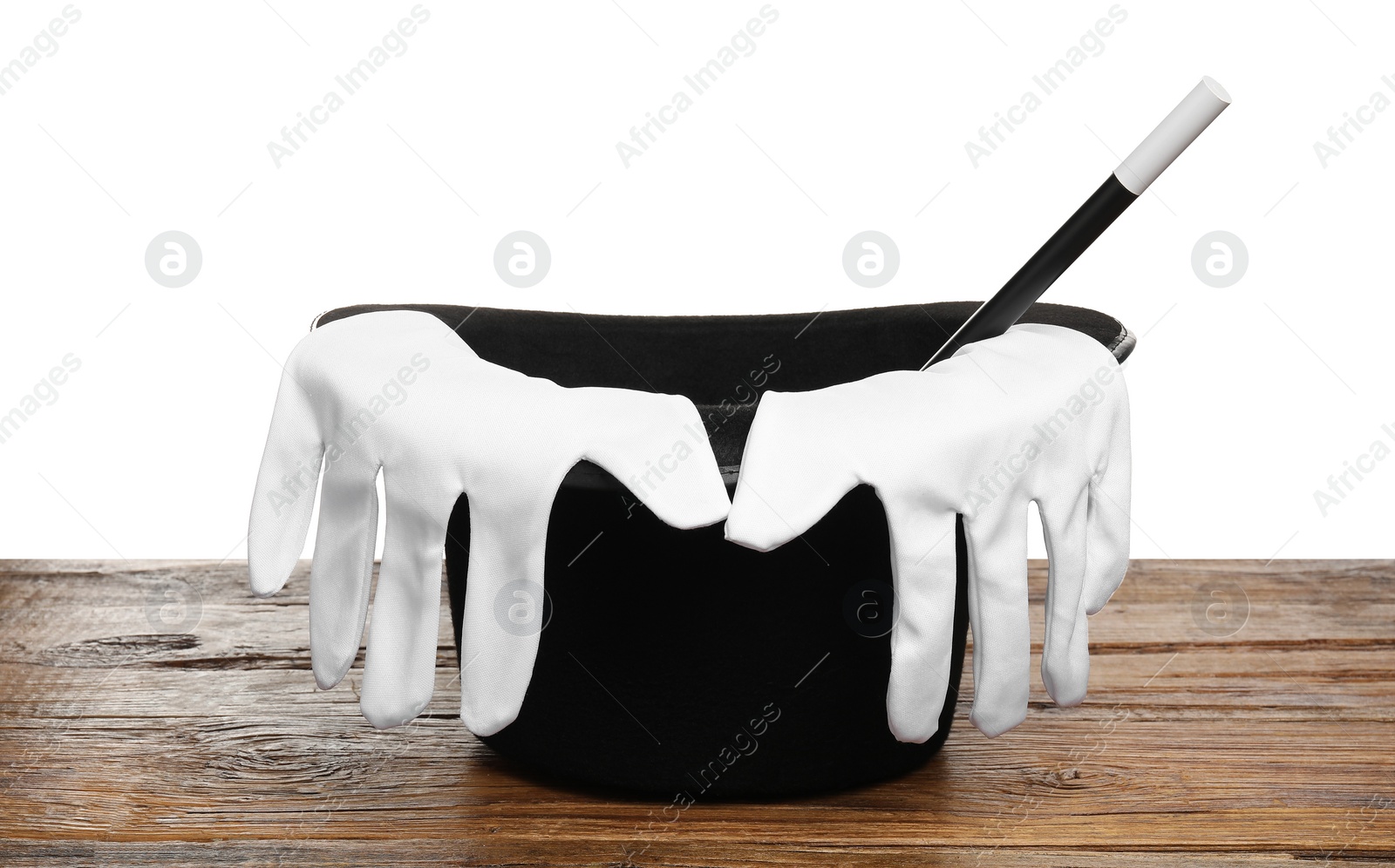 Photo of Magician's hat, gloves and wand on wooden table against white background