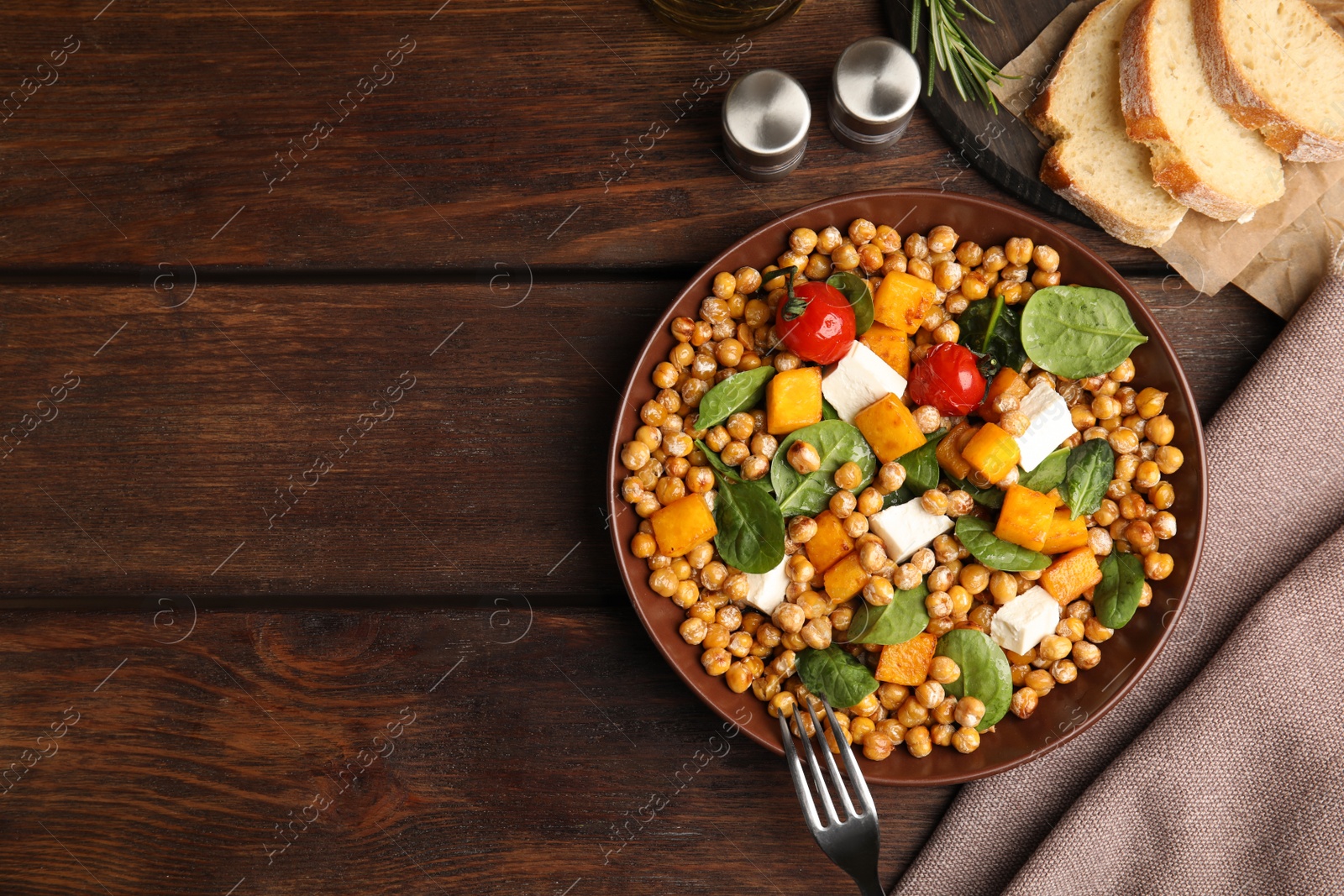 Photo of Delicious fresh chickpea salad served on wooden table, flat lay. Space for text