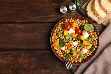 Delicious fresh chickpea salad served on wooden table, flat lay. Space for text