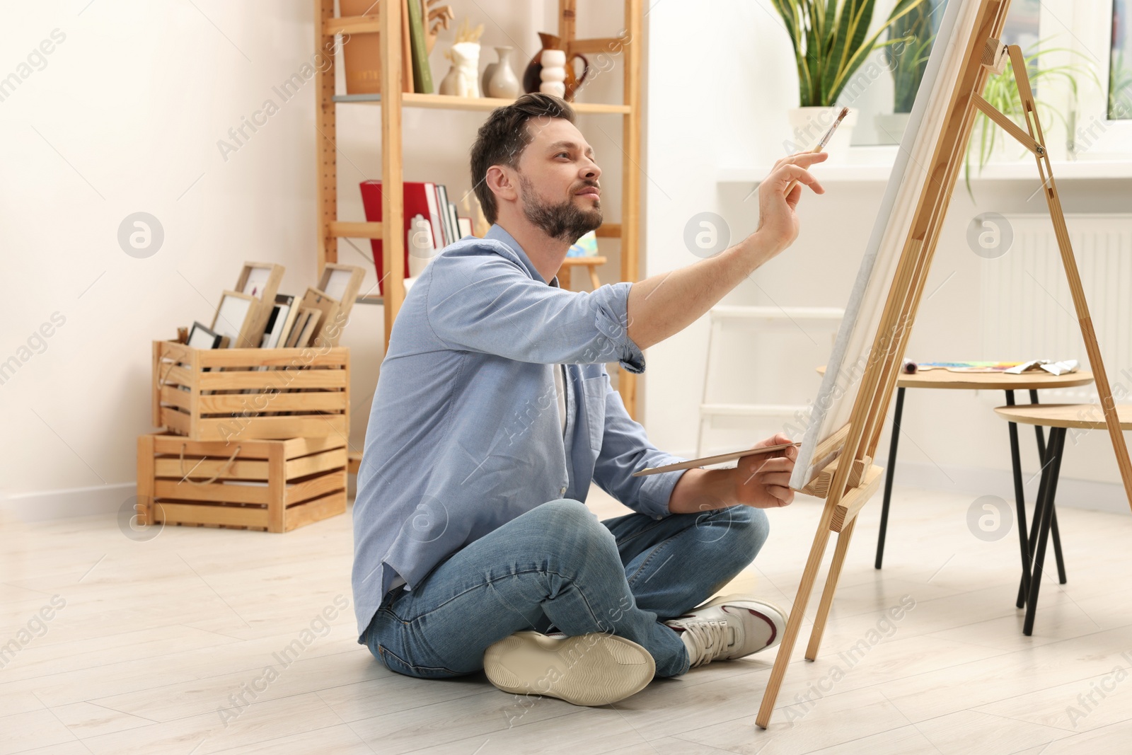 Photo of Handsome man painting in studio. Creative hobby