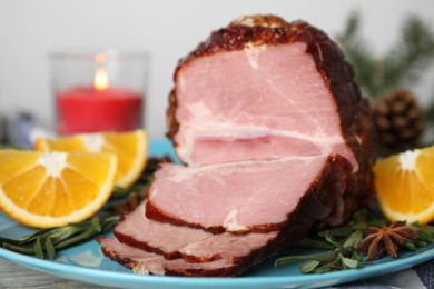 Plate with delicious ham, rosemary and orange on white table. Christmas dinner