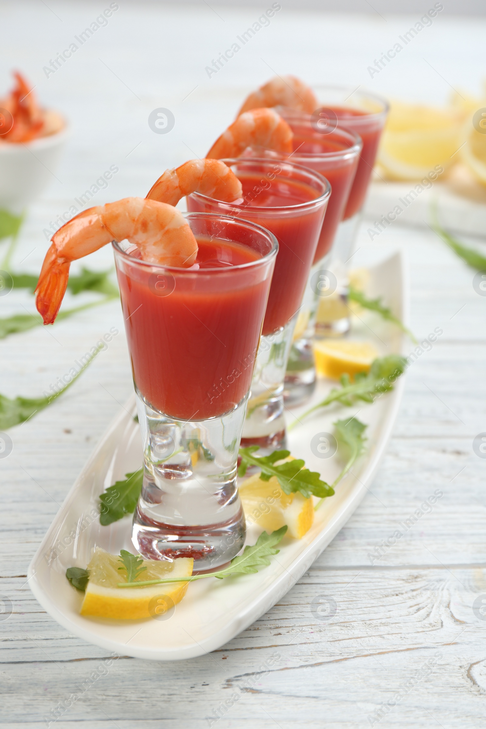 Photo of Shrimp cocktail with tomato sauce on white wooden table