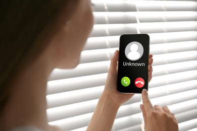 Image of Woman declining incoming call from unknown caller indoors, closeup. Be careful - fraud