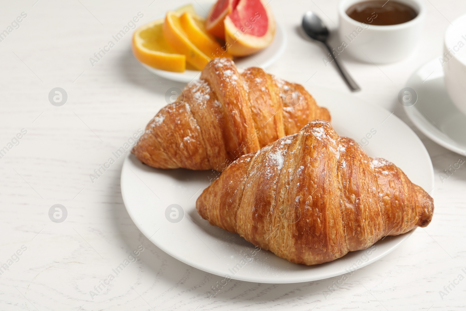 Photo of Tasty fresh croissants on white wooden table. Healthy breakfast