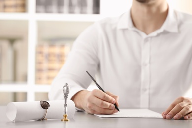 Photo of Male notary working with documents at table indoors, closeup