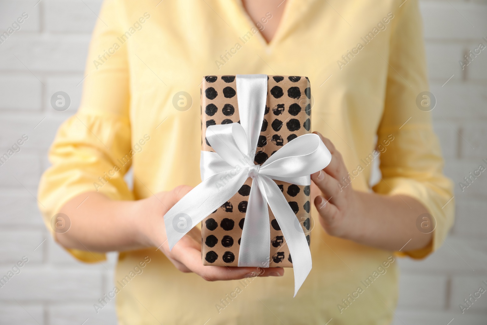 Photo of Woman holding beautiful gift box, closeup