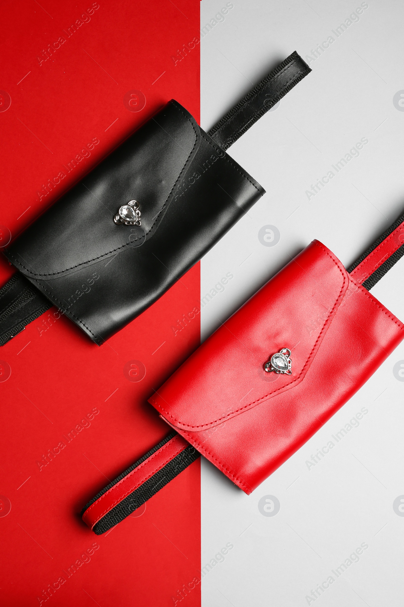 Photo of Flat lay composition of stylish bum bags on color background