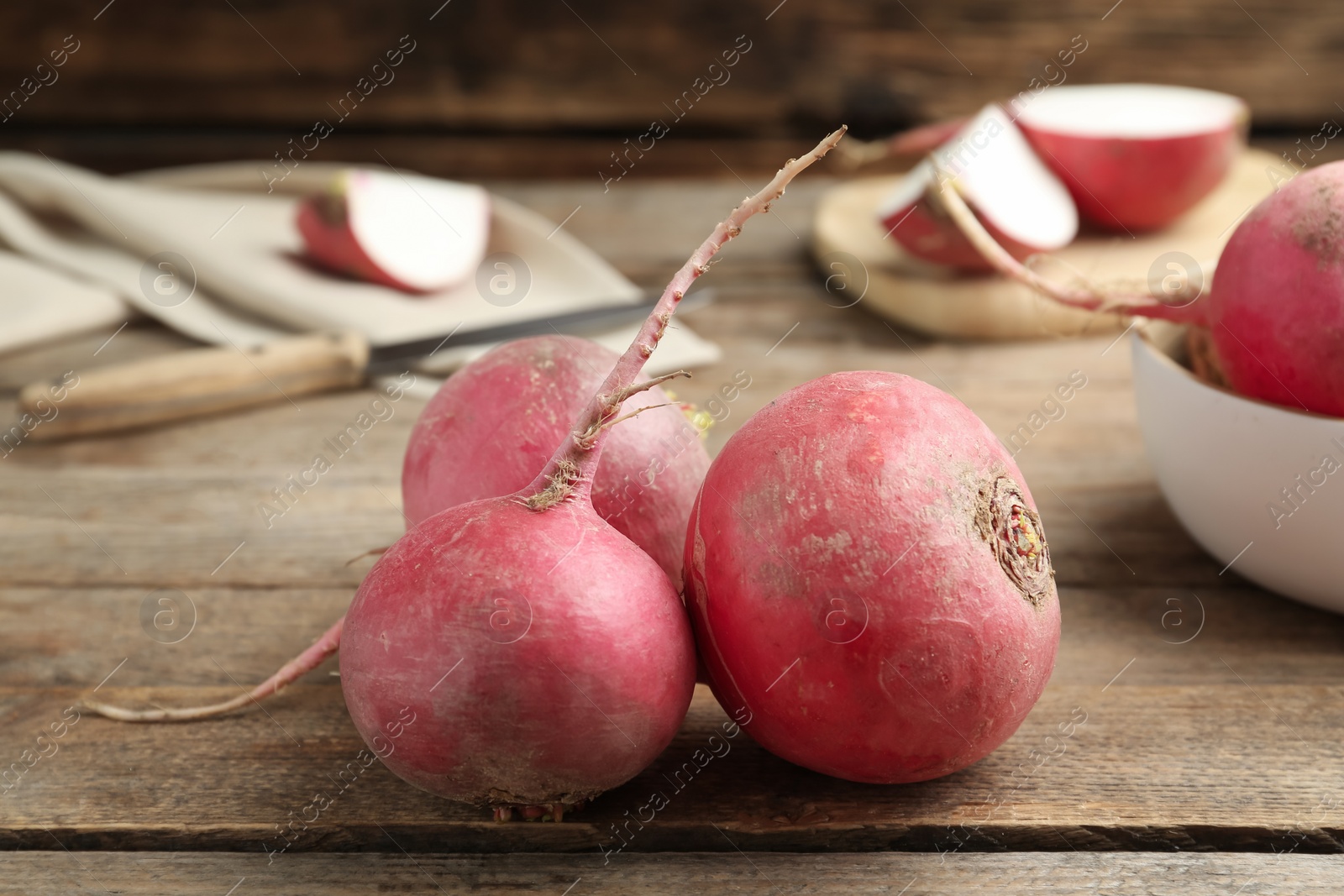 Photo of Raw red turnips on wooden table, closeup