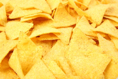 Photo of Tasty Mexican nachos chips as background, closeup