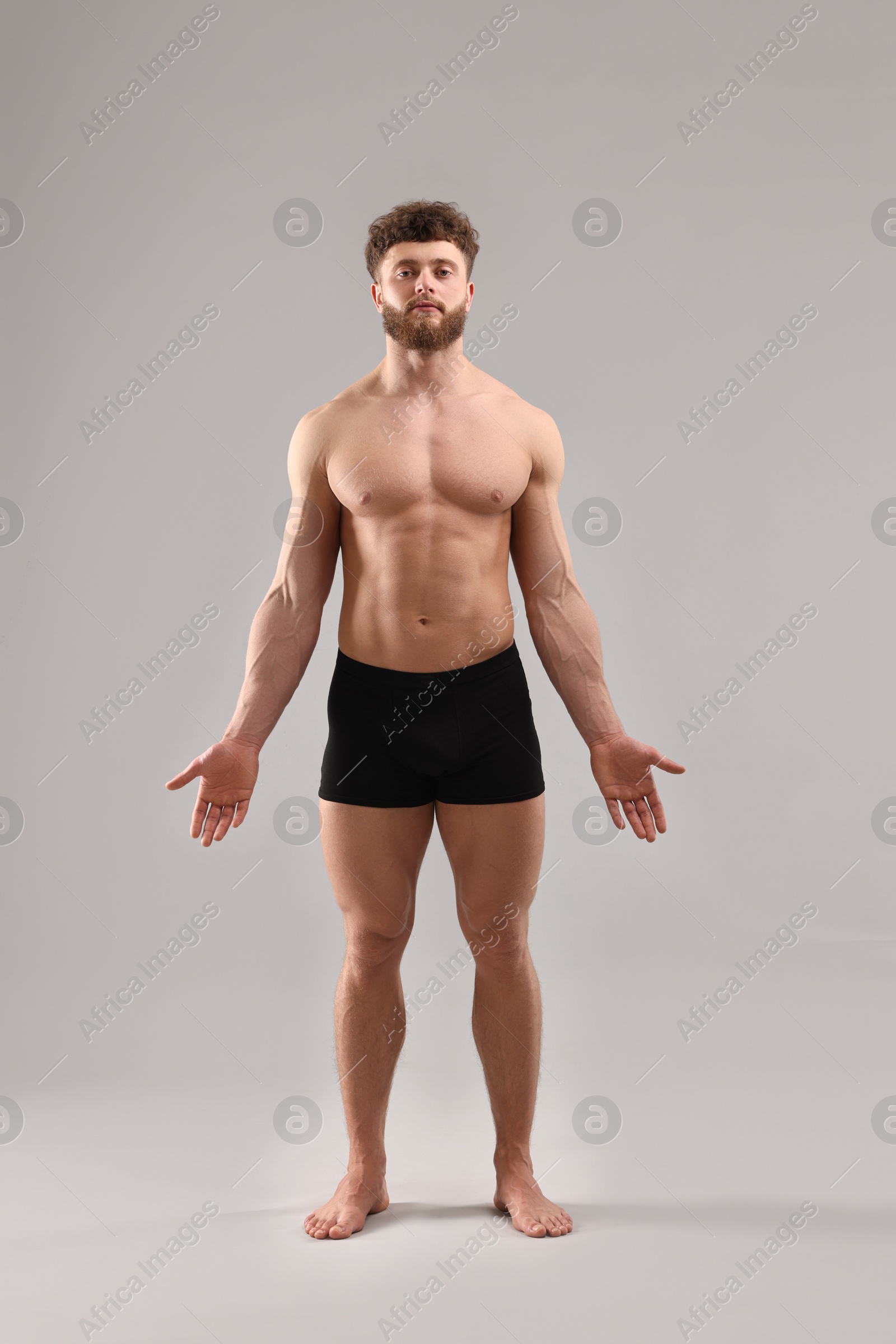 Photo of Handsome man with muscular body on light grey background