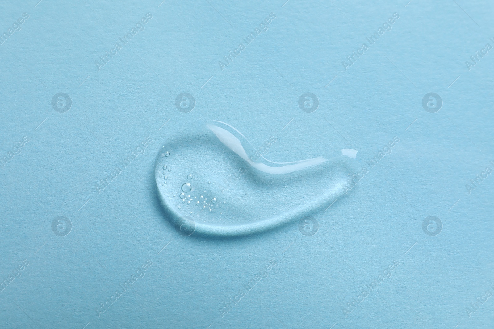 Photo of Sample of transparent gel on light blue background, top view