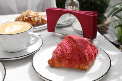 Delicious croissant and coffee on white marble table