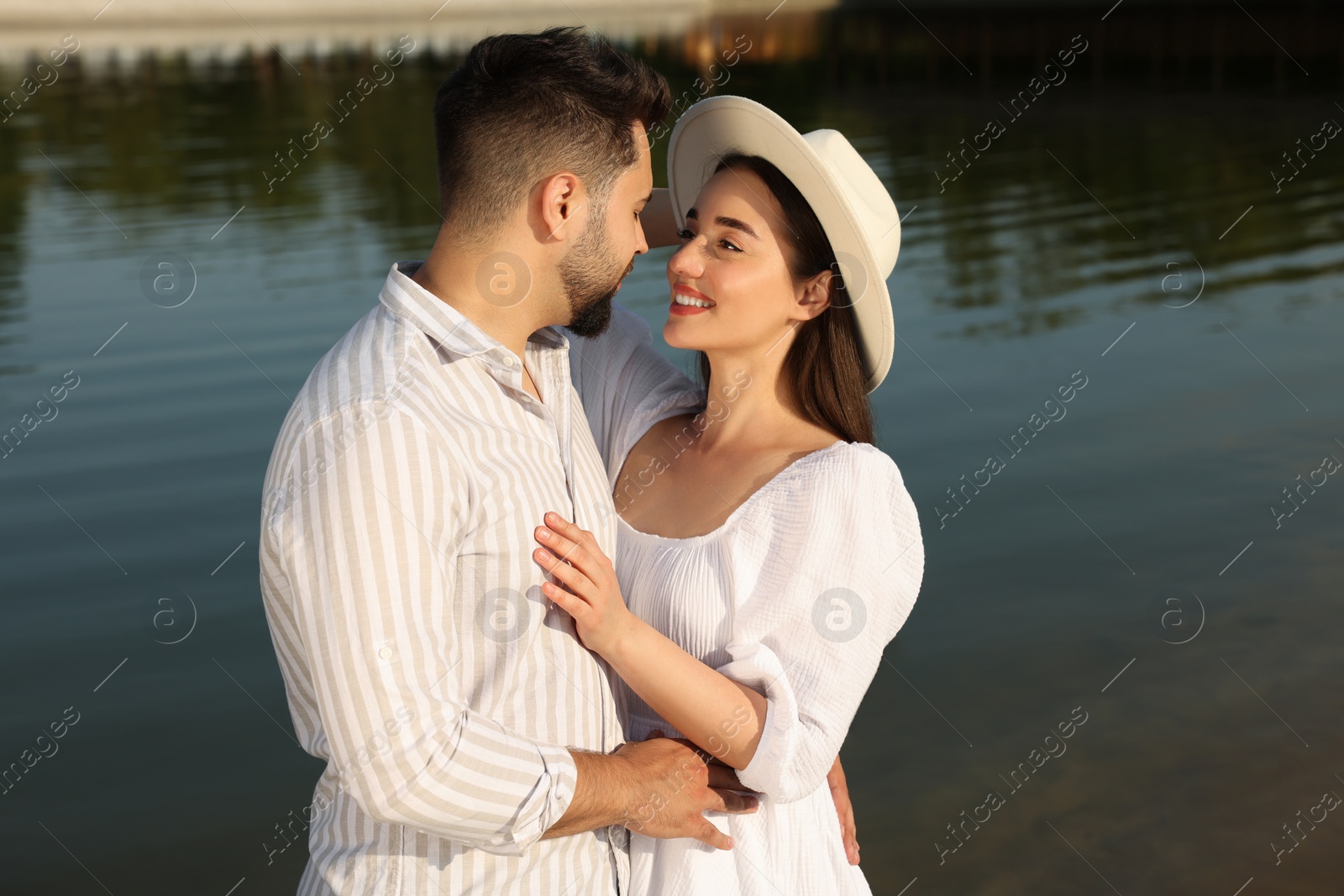 Photo of Romantic date. Beautiful couple spending time together near lake