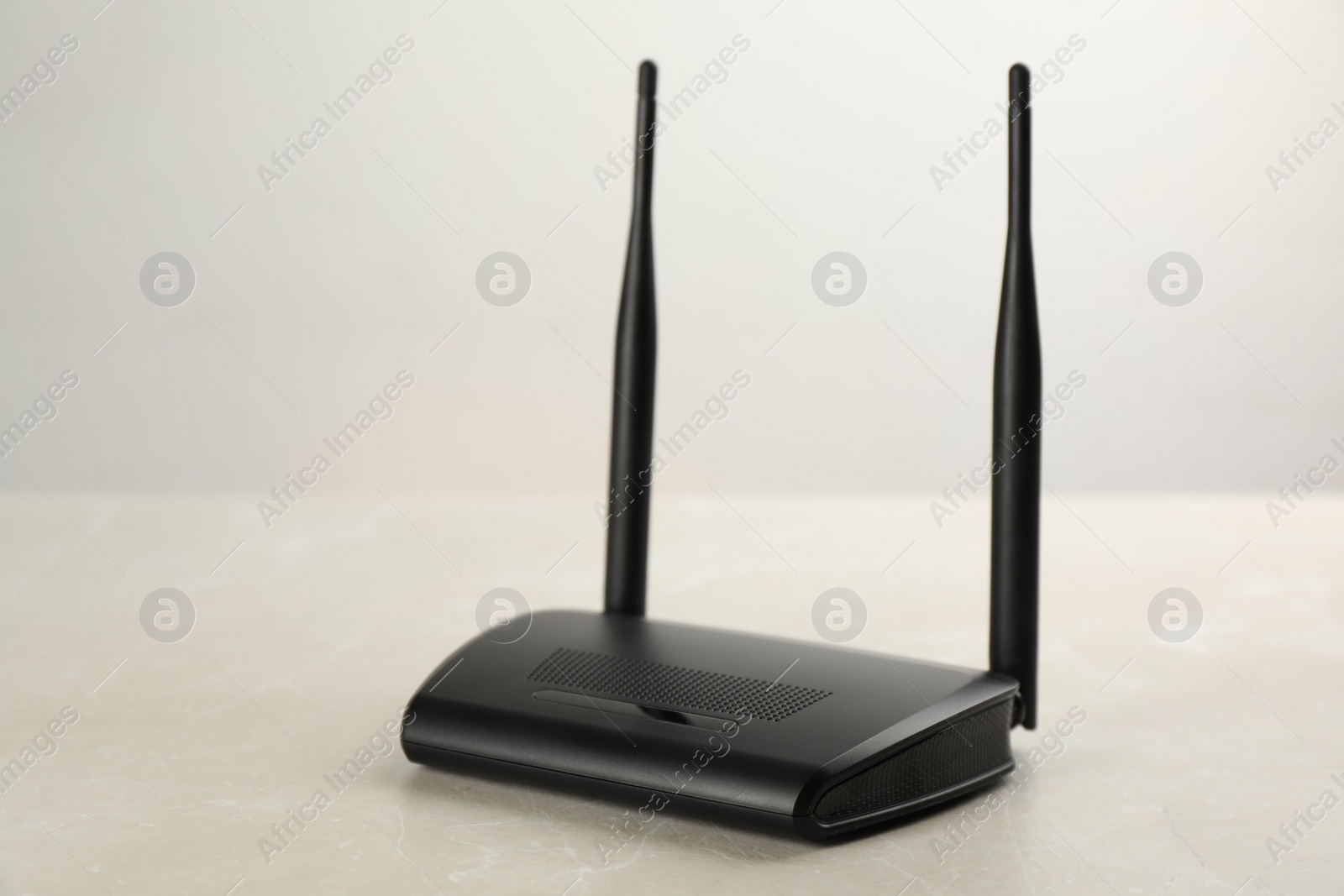 Photo of Modern Wi-Fi router on light grey marble background