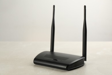 Modern Wi-Fi router on light grey marble background