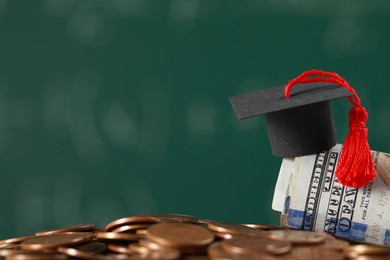 Photo of Scholarship concept. Graduation cap, coins and dollar banknotes against blurred background, closeup. Space for text