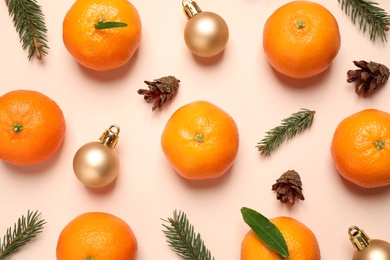 Photo of Composition with Christmas balls and tangerines on beige background, flat lay