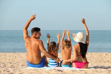 Happy family on sandy beach near sea. Summer holidays