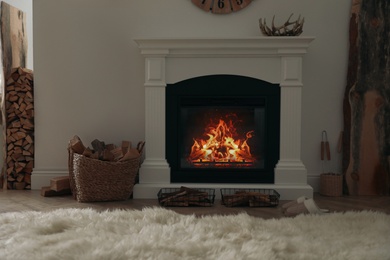 Photo of Firewood burning bright in elegant hearth indoors