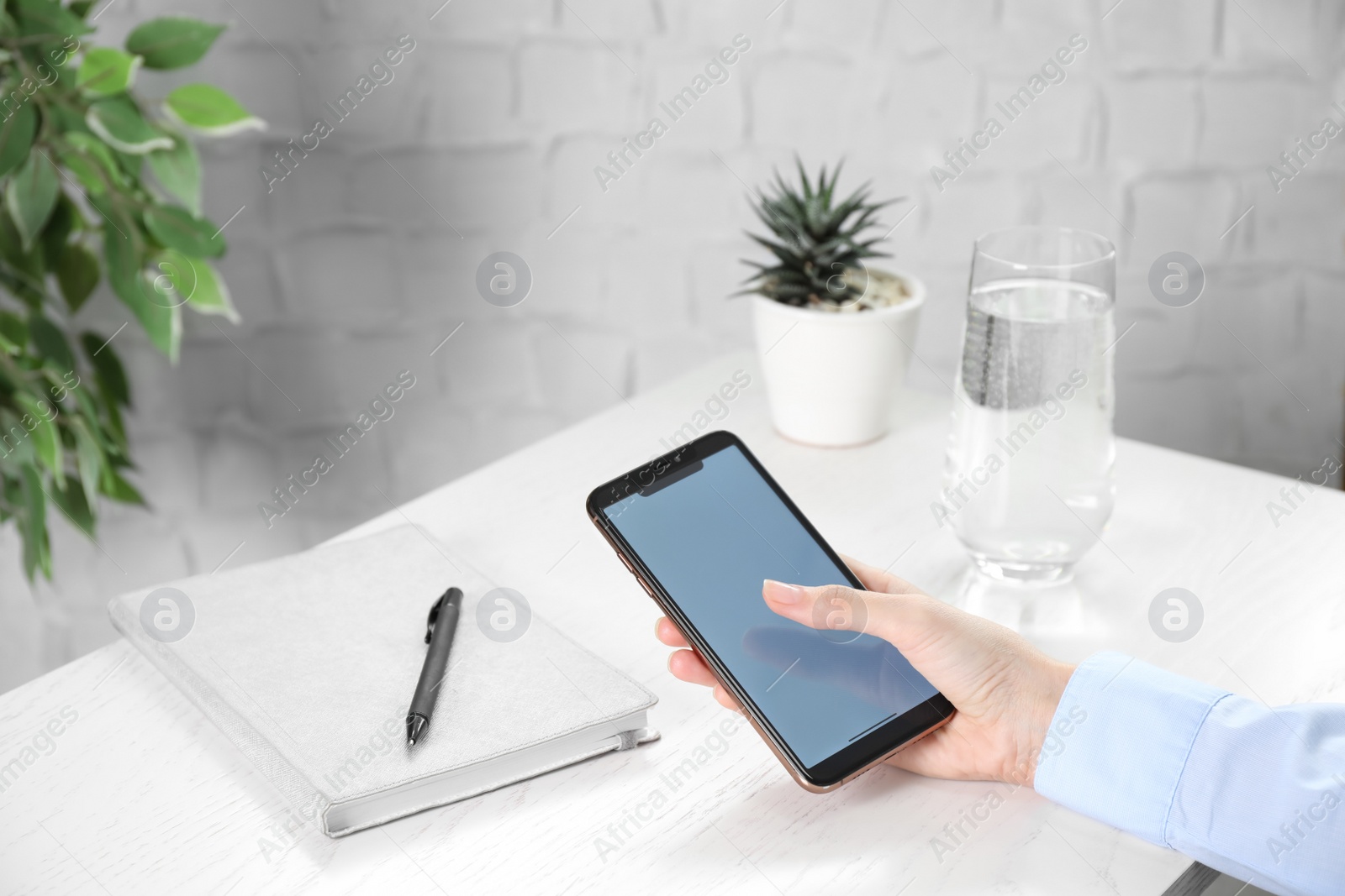 Photo of Woman using modern smartphone at table indoors, closeup