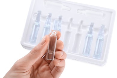 Photo of Woman holding glass ampoule with medication on white background, top view