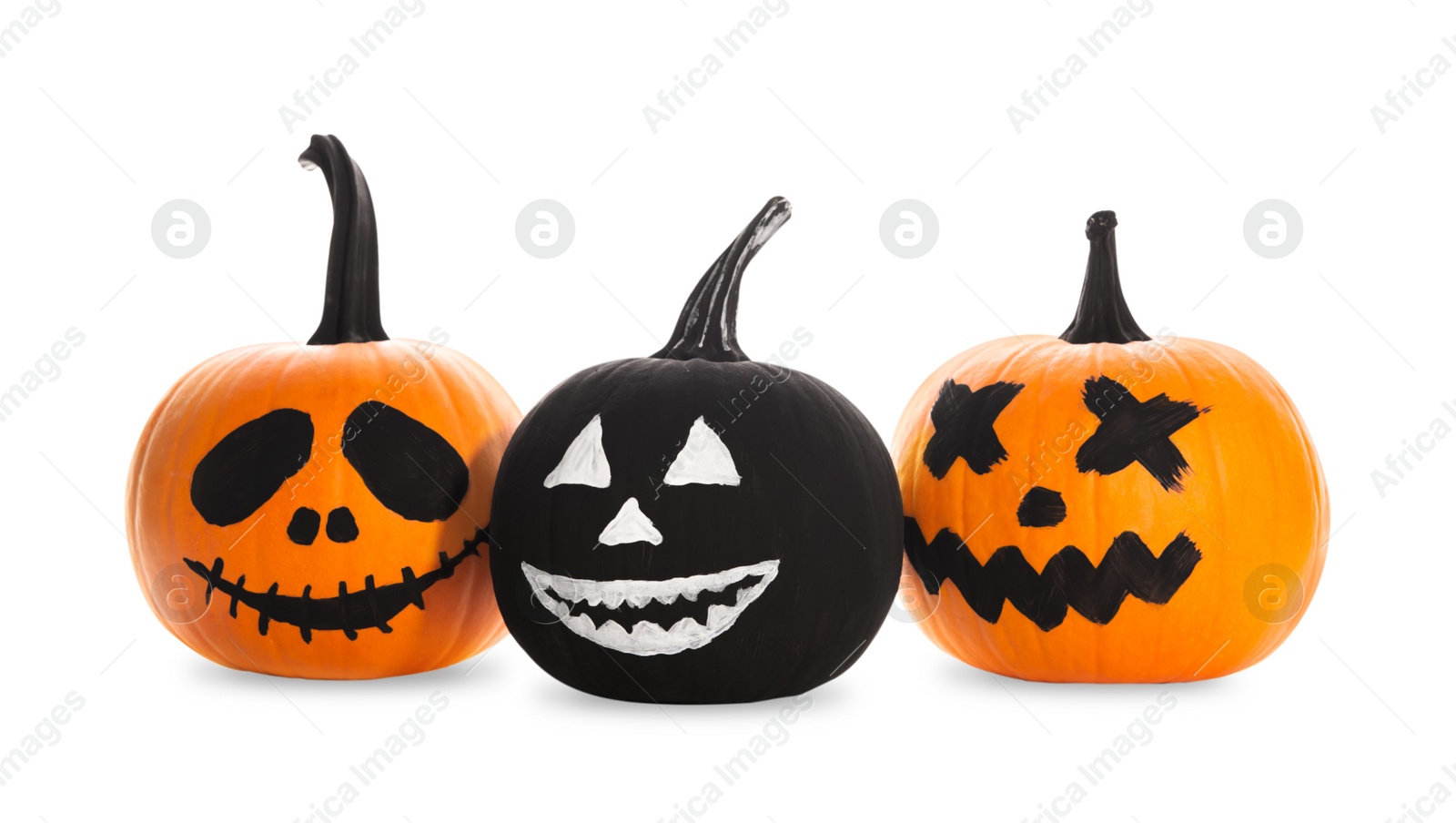 Photo of Halloween pumpkins with scary drawn faces on white background