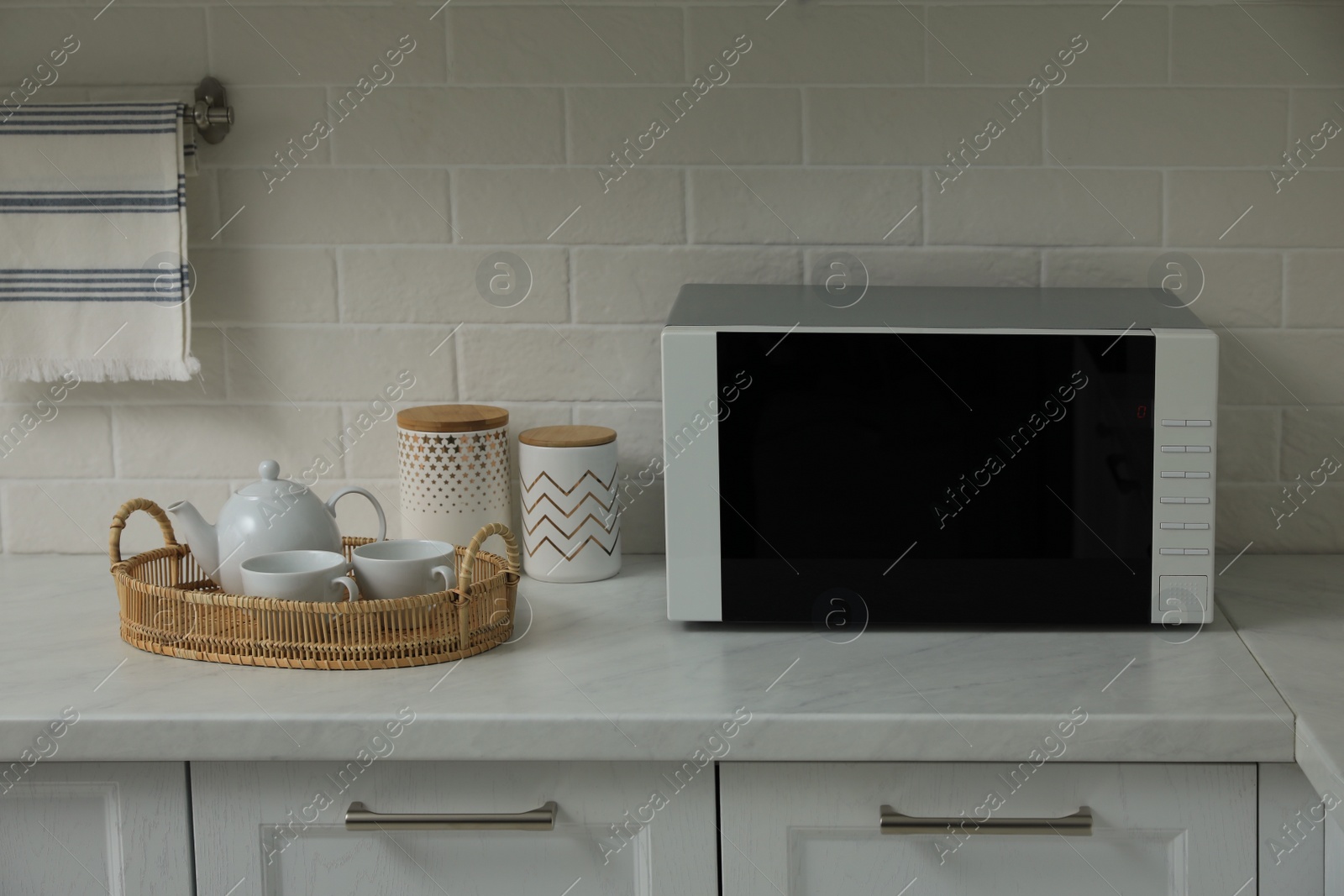 Photo of Modern microwave oven on countertop in kitchen