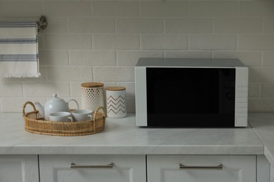 Photo of Modern microwave oven on countertop in kitchen