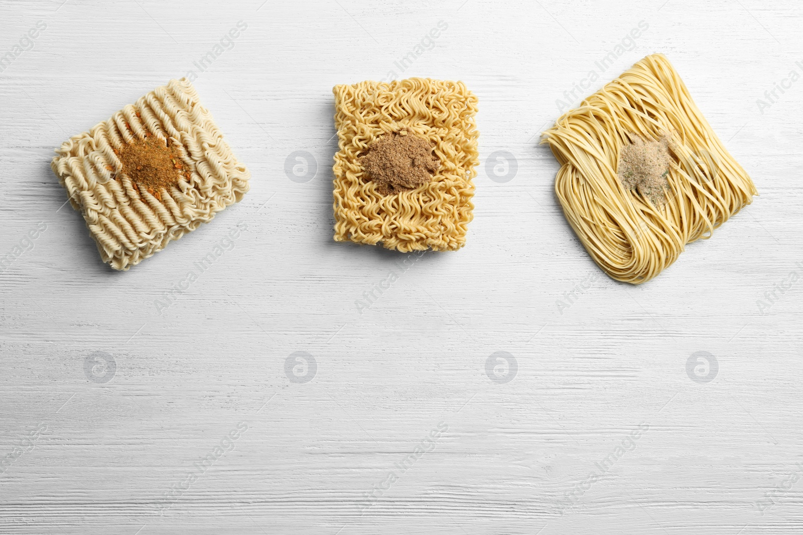 Photo of Flat lay composition with different quick cooking noodles on wooden background. Space for text