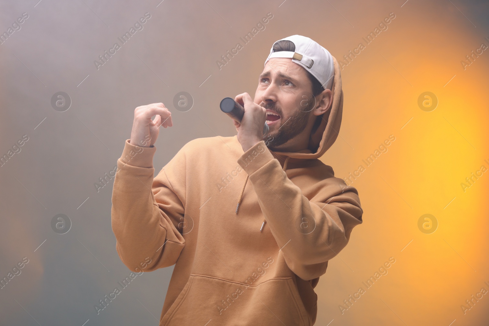 Photo of Singer with microphone rapping in color lights