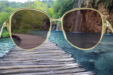 Image of Wooden bridge over lake, view through sunglasses
