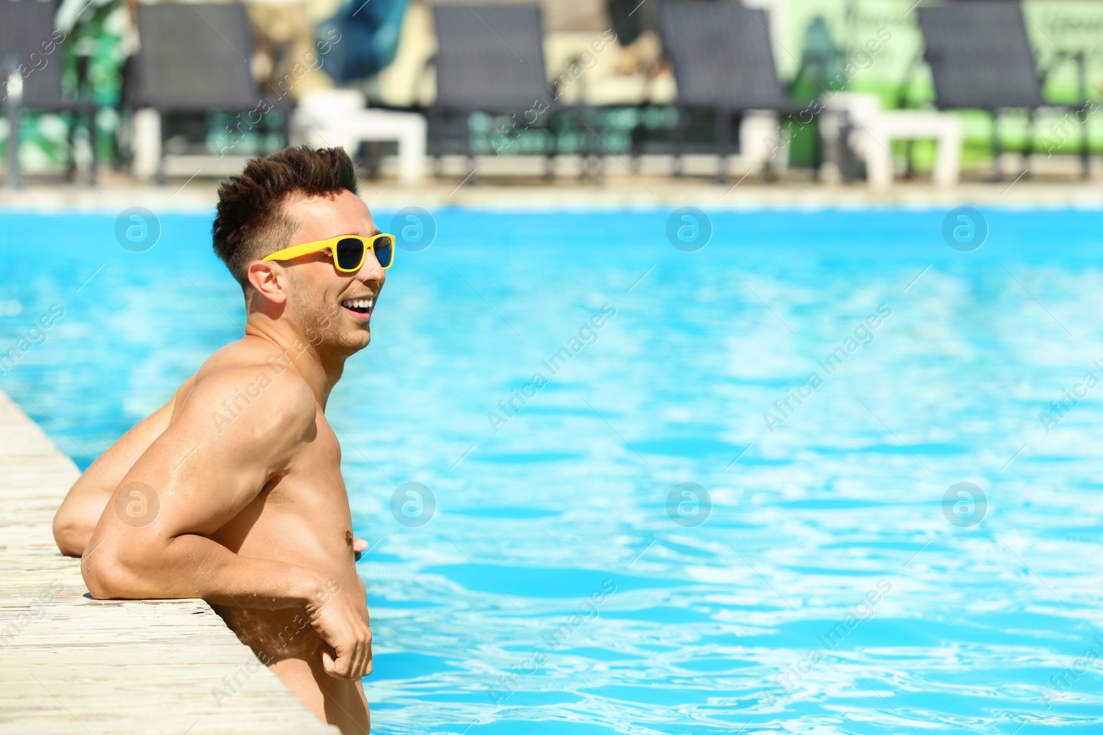 Photo of Happy young man in swimming pool on sunny day