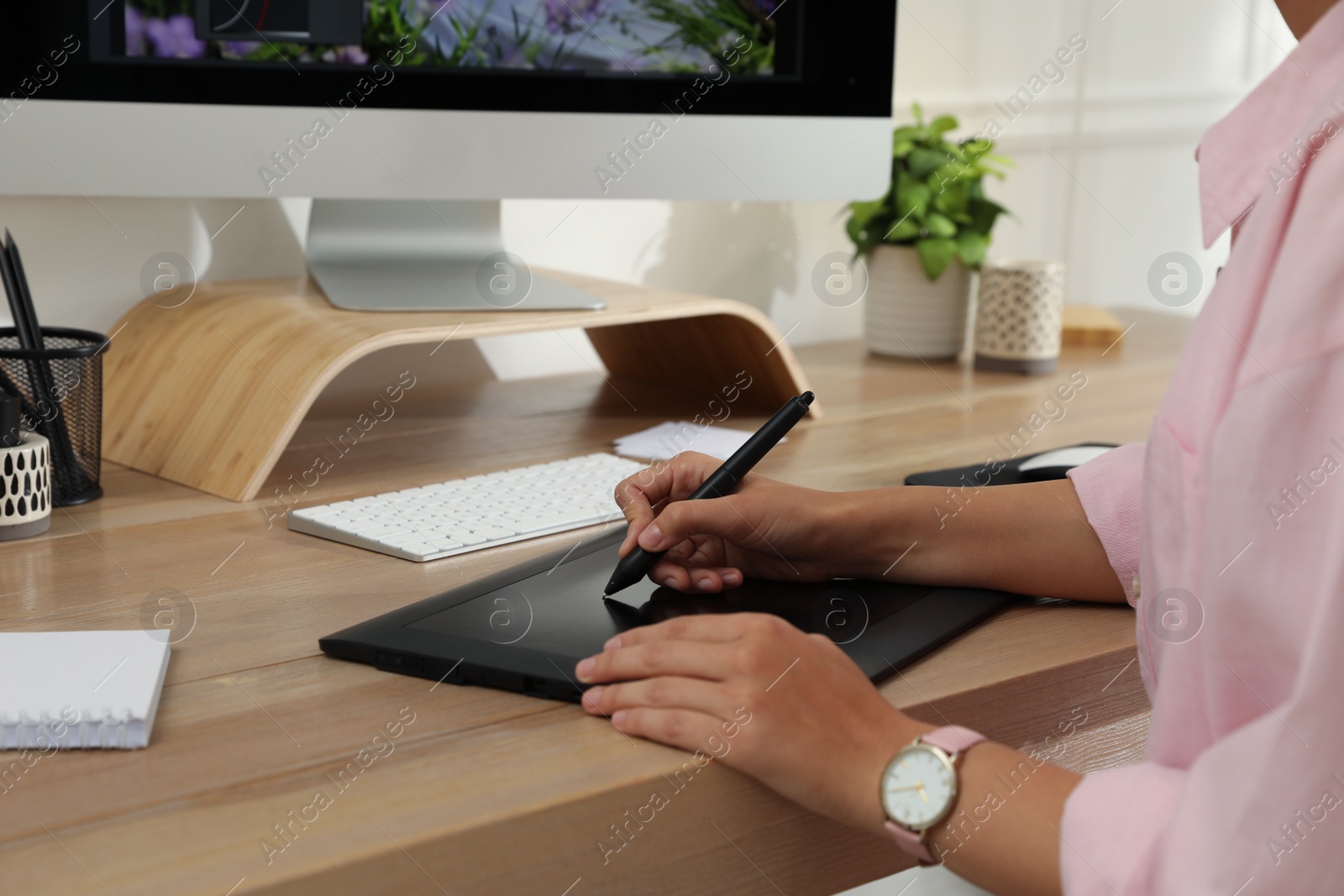 Photo of Professional retoucher working on graphic tablet at desk, closeup