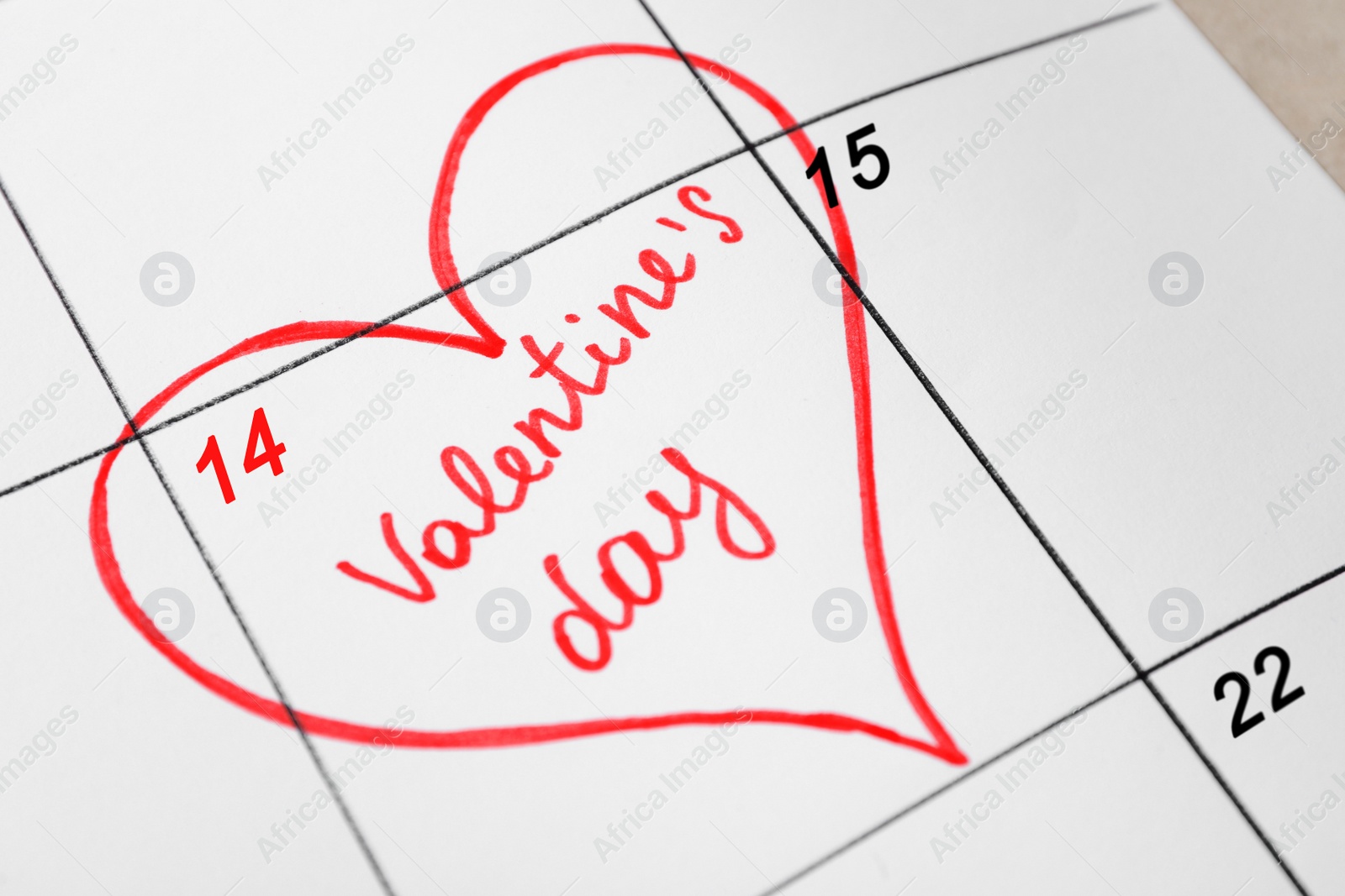 Photo of Calendar with marked Valentine's Day on table, closeup