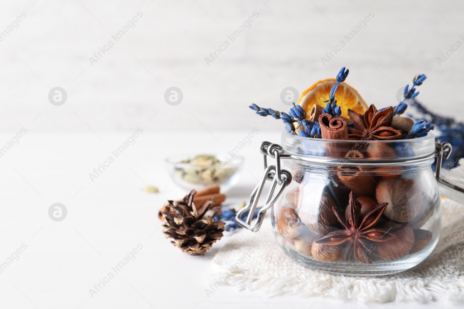 Photo of Aromatic potpourri in glass jar on white background. Space for text