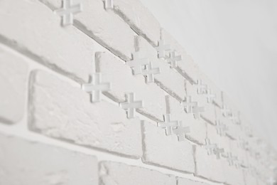 Decorative white bricks with tile leveling system on wall