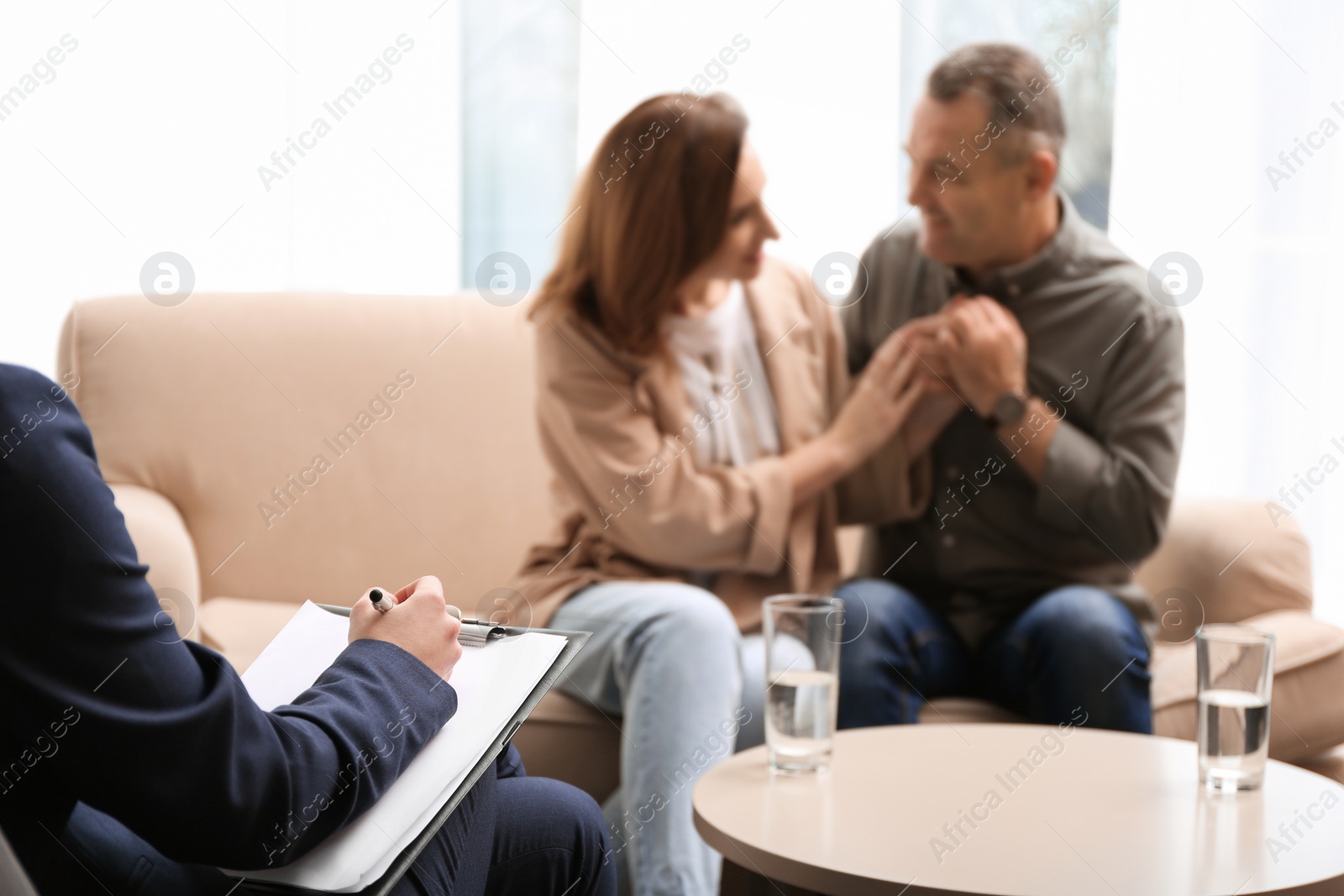 Photo of Psychotherapist and happy couple having meeting in office. Family counselling