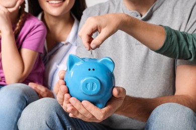 Happy family with coin and piggy bank, closeup