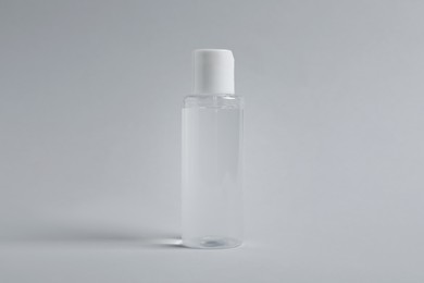 Bottle of cosmetic product on light grey background