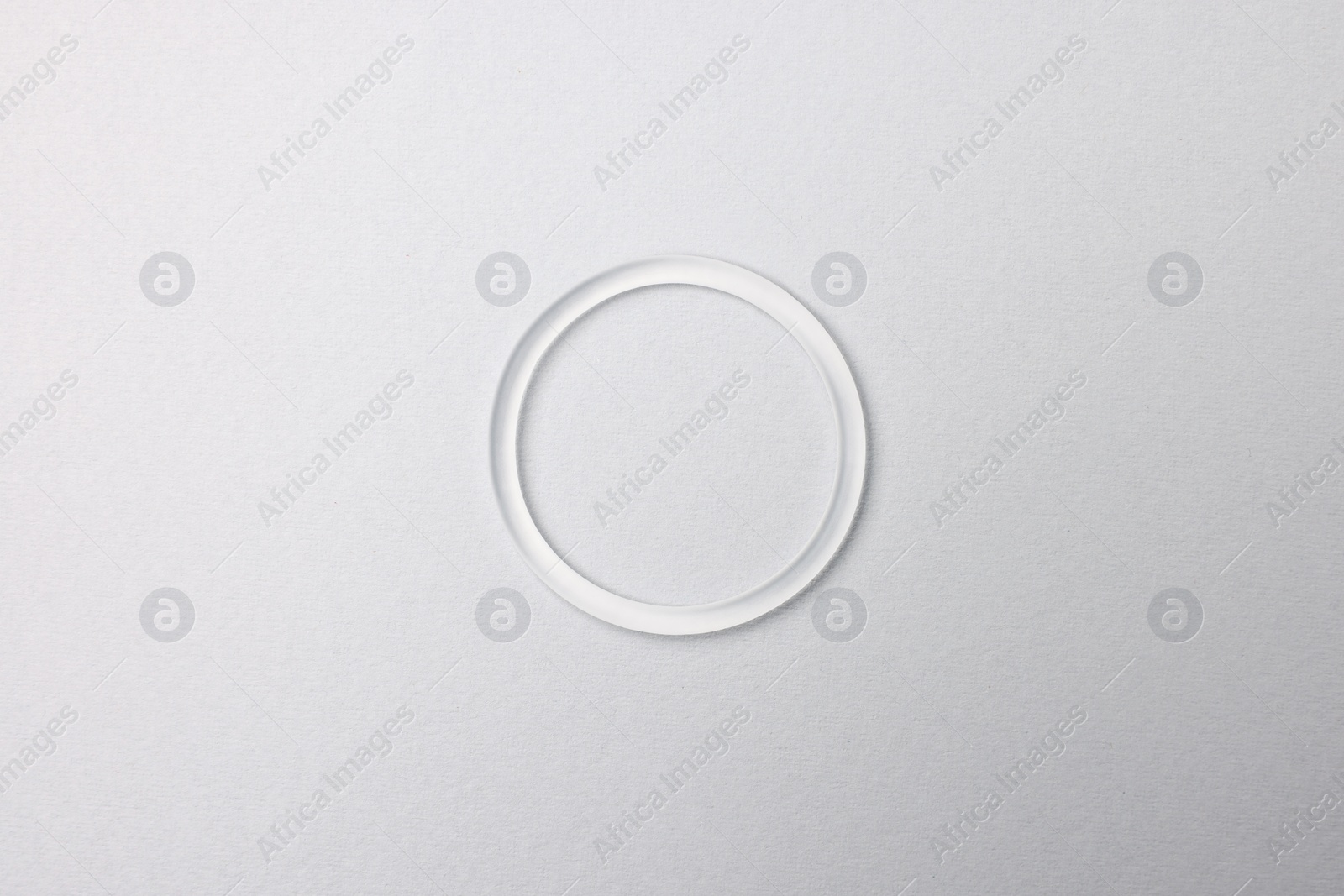 Photo of Diaphragm vaginal contraceptive ring on grey background, top view