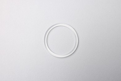 Diaphragm vaginal contraceptive ring on grey background, top view